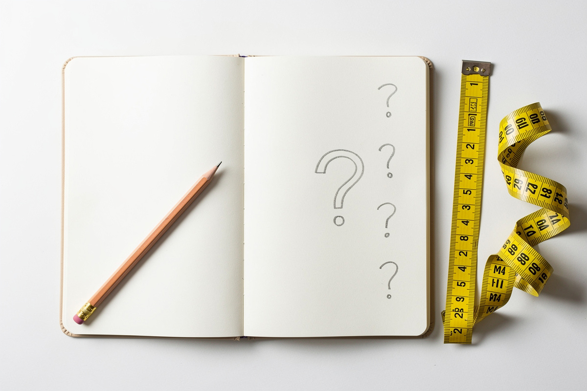 Carnet ouvert avec outils d'artisan illustrant les questions fréquentes sur la relance de devis artisan