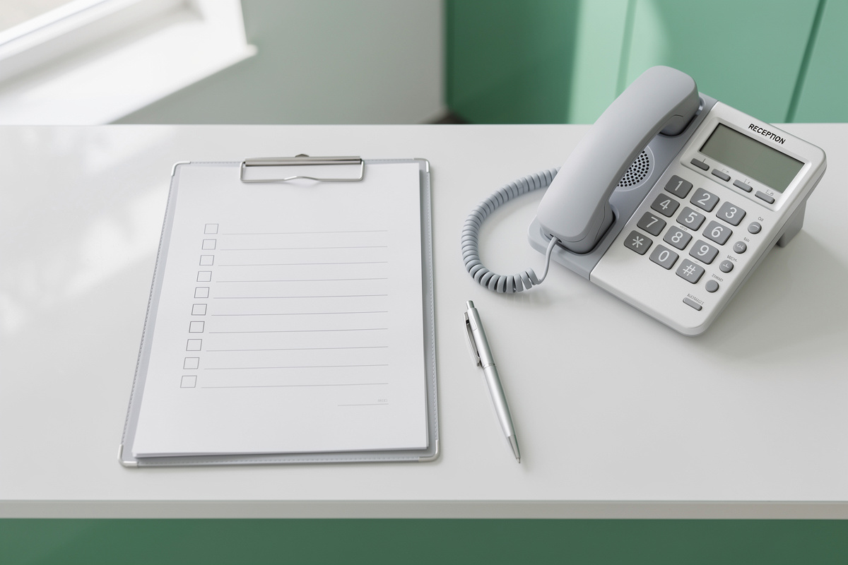 Checklist de conformité de l'accueil téléphonique vétérinaire posée près d'un standard de cabinet